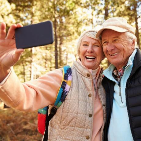 Starší pár na túre v lese, ktorý si robí selfie