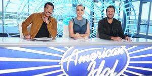 lionel richie, katy perry a luke bryan sedia pri stole s logom American idol na prednej strane