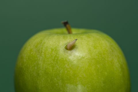 Červ sa vystrkuje zo zeleného jablka