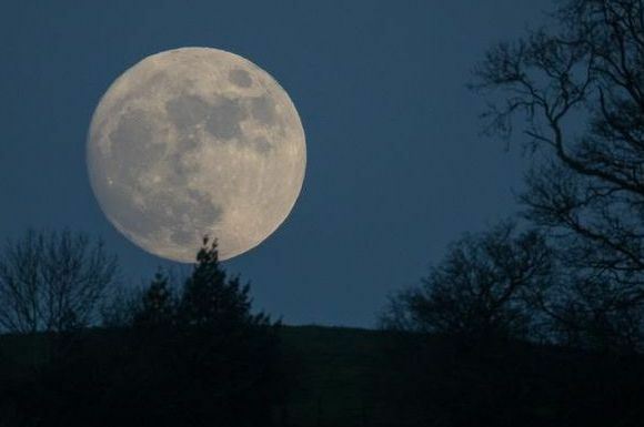 vlčí mesiac vychádza nad glastonbury pred splnenými úradnými výstrahami pred nepriaznivým počasím