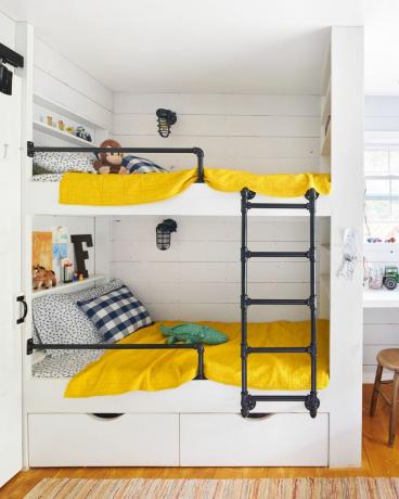 moderná poschodová posteľ na farme s priemyselným rebríkom a žiarivo žltými posteľami