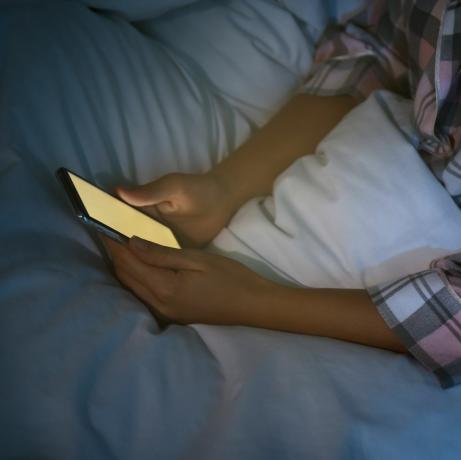 žena používa smartfón v noci v posteli, detailná nomofóbia a problém s poruchou spánku