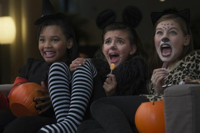 dievčatá v kostýmoch spolu sledujú strašidelný film na halloweene