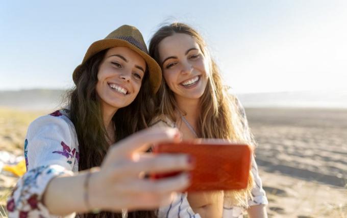 dvaja najlepší priatelia, ktorí si robia selfie so smartfónom na pláži