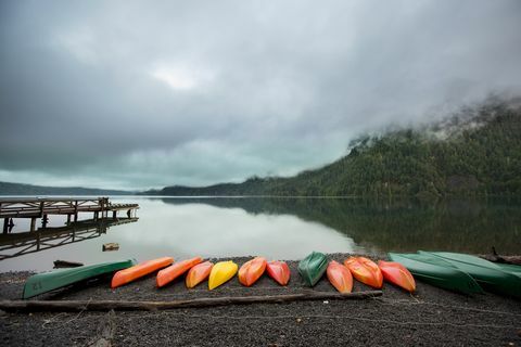 séria farebných kanoe pozdĺž brehu jazera
