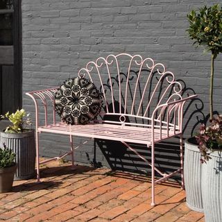 Pekná ružová kovová záhradná lavička