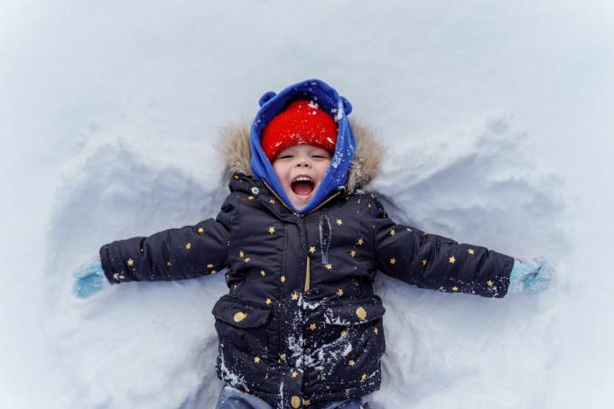 malé dieťa v snehu robí snehového anjela