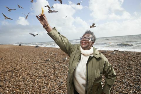 staršia žena kŕmenie hranolčekmi vtákovi